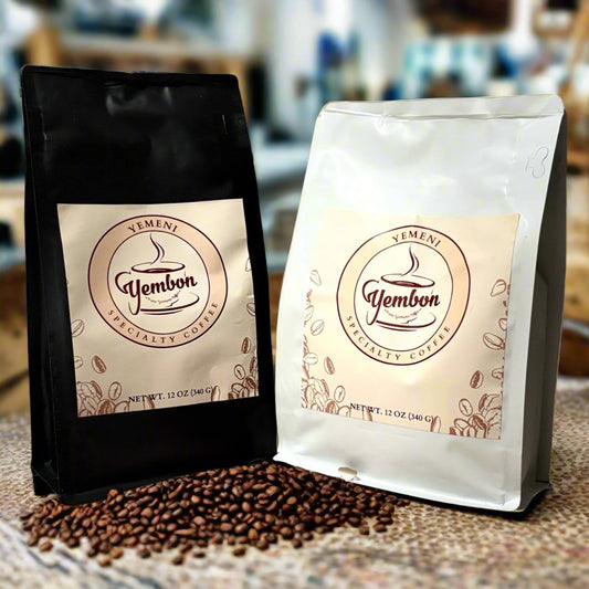 Two coffee bags with 'Yembon' branding on a clay surface with coffee beans and plants in the background.